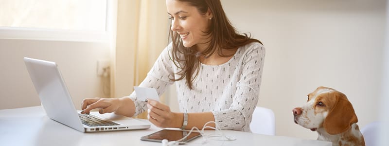 woman at computer and credit card and dog